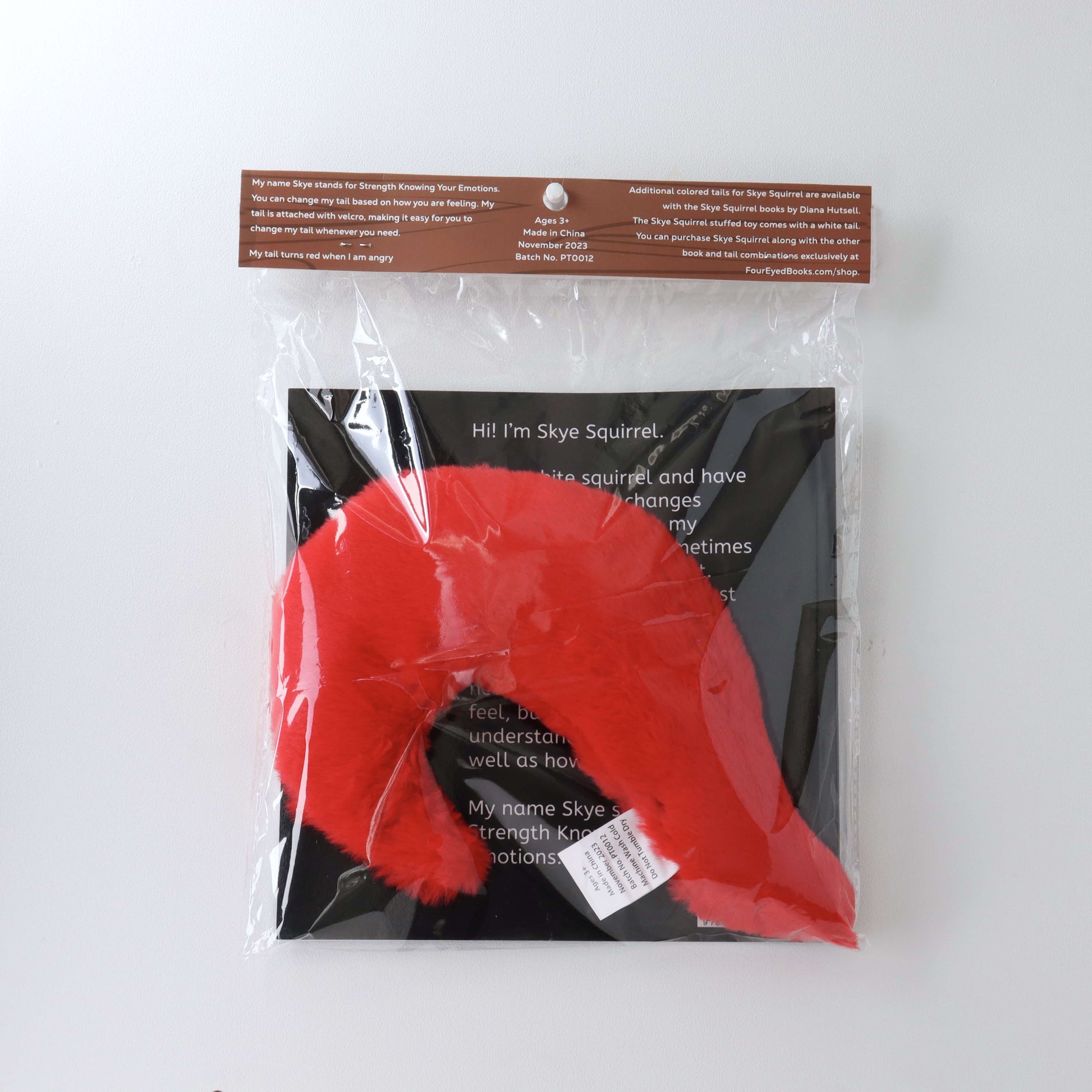 Red Stuffed Tail in plastic packaging with book (back)