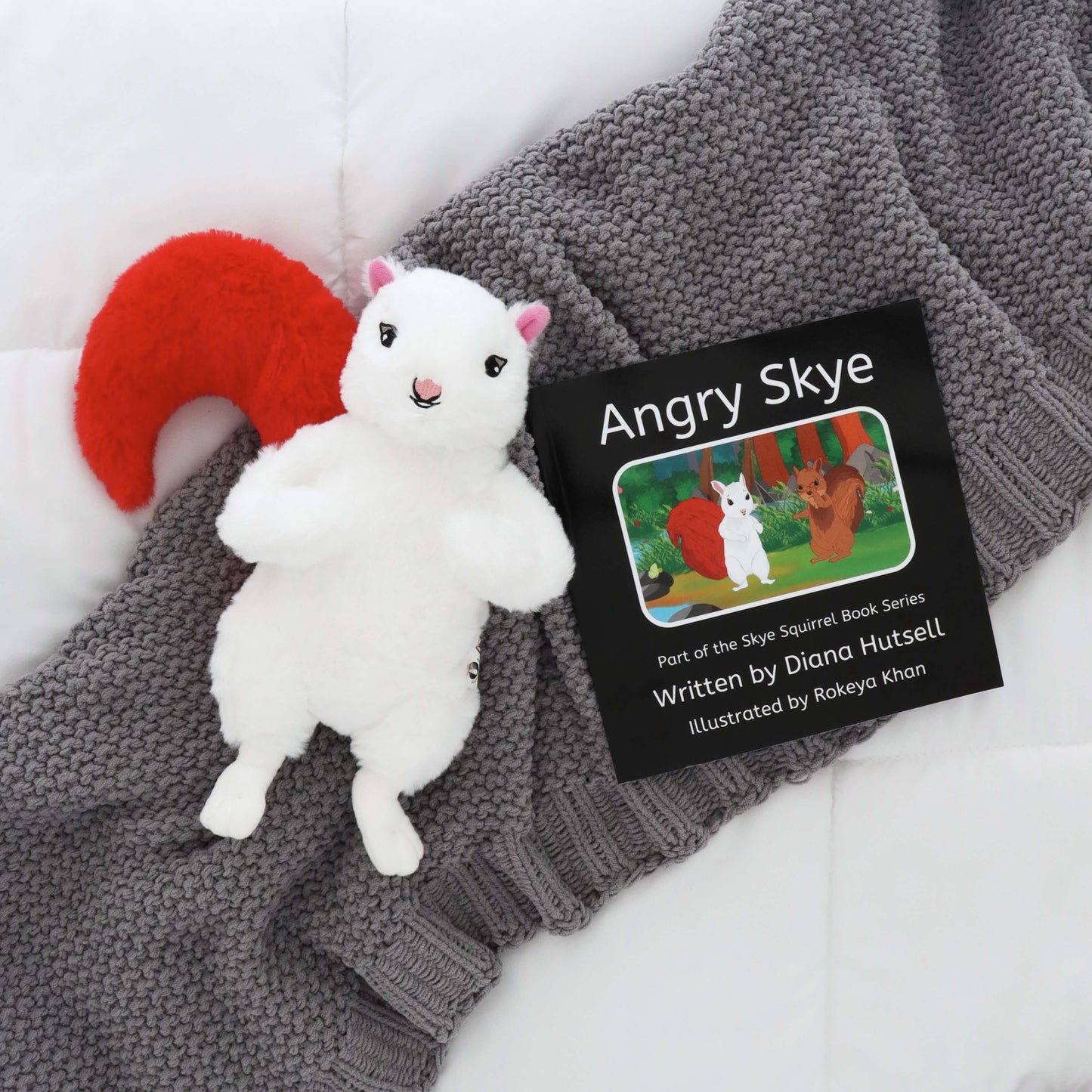 Angry Skye Book with Skye Squirrel with Red Stuffed Tail on a gray blanket