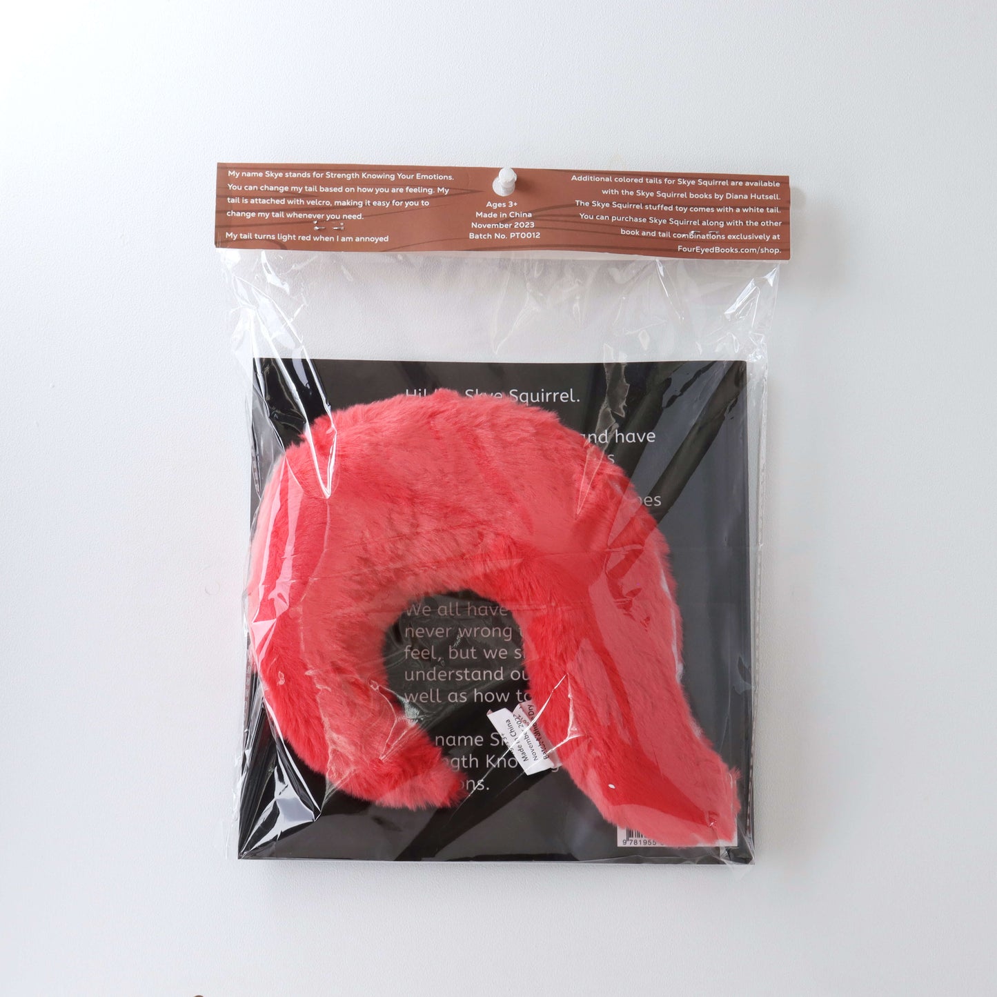 Light Red Stuffed Tail in plastic packaging with book (back)