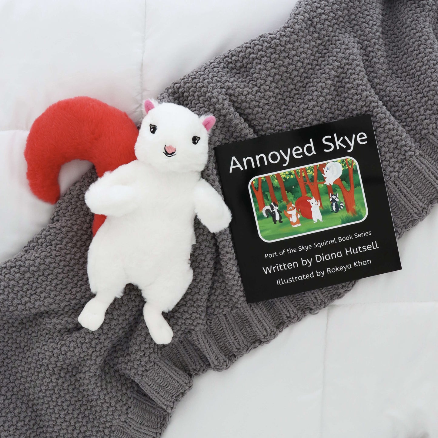 Annoyed Skye Book with Skye Squirrel with Light Red Stuffed Tail on a gray blanket